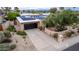 Well-maintained home featuring xeriscaping, desert plants, a dark garage door and solar panels at 3258 E Vogel Ave, Phoenix, AZ 85028