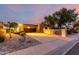 Front exterior showcases desert landscaping, mature trees, and a paved driveway leading to the home at sunset at 3258 E Vogel Ave, Phoenix, AZ 85028
