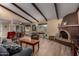 Spacious living room featuring a brick fireplace, exposed beams, and wood-look floors, creating a warm and inviting atmosphere at 3258 E Vogel Ave, Phoenix, AZ 85028