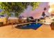Backyard pool area with desert landscaping, including cacti and palm trees, and a beautiful dusk sky at 3258 E Vogel Ave, Phoenix, AZ 85028