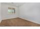 This cozy bedroom is bright, has carpet, white walls and trim, and a window with plantation shutters at 33395 N 132Nd Dr, Peoria, AZ 85383