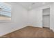 This bedroom is bright, has carpet, white walls and trim, and a sliding door closet with shelving at 33395 N 132Nd Dr, Peoria, AZ 85383