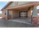 Covered patio featuring concrete flooring, brick pillars, and sliding glass doors to the interior at 33395 N 132Nd Dr, Peoria, AZ 85383
