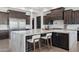 Elegant kitchen features a large marble island, dark wood cabinetry, and modern stainless steel appliances at 3939 W Fox Rd, Laveen, AZ 85339
