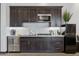 Modern kitchenette featuring dark wood cabinetry, stainless steel appliances, and marble backsplash at 3939 W Fox Rd, Laveen, AZ 85339