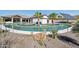 Wide angle view of a custom pool design with rock and desert plant features, surrounded by green turf at 3939 W Fox Rd, Laveen, AZ 85339