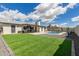 Expansive backyard featuring lush green grass, mature trees, a sparkling pool, and a covered patio for outdoor enjoyment at 5129 W Echo Ln, Glendale, AZ 85302