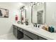 Bright bathroom featuring dual sinks, modern fixtures, white countertops, and gray cabinets offering lots of storage space at 5129 W Echo Ln, Glendale, AZ 85302