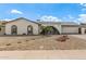 Charming home exterior with arched entry, desert landscaping, and attached two-car garage at 5129 W Echo Ln, Glendale, AZ 85302