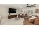 Bright living room featuring marble floors, plush sofas, a modern ceiling fan, and large TV at 5129 W Echo Ln, Glendale, AZ 85302