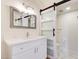 Bathroom with white marble floors, vanity, and sliding barn door to toilet room at 5607 N 76Th Pl, Scottsdale, AZ 85250