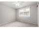 Bright bedroom features a neutral carpet, ceiling fan, and a window with blinds at 6514 S Lakeshore Dr # C, Tempe, AZ 85283