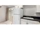 Cozy kitchen features white appliances, black countertops, and access to the patio at 6514 S Lakeshore Dr # C, Tempe, AZ 85283