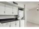 Bright laundry area featuring white cabinets, black countertop, and a stackable washer and dryer at 6514 S Lakeshore Dr # C, Tempe, AZ 85283
