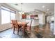 Bright dining area with tiled flooring, wooden table set, pendant lighting, and breakfast bar with view of the kitchen at 6796 W Evergreen Ter, Peoria, AZ 85383