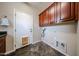 Functional laundry room with cabinetry, slate floors, and door to the exterior at 6796 W Evergreen Ter, Peoria, AZ 85383