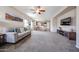 Spacious living room with carpet, sofa, tv and easy access to both the dining area and kitchen at 6796 W Evergreen Ter, Peoria, AZ 85383