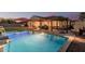 Lush backyard featuring a sparkling pool, outdoor kitchen, dining area, and sport court, perfect for entertaining at 7589 W Firebird Dr, Glendale, AZ 85308