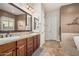 Bathroom boasts double sinks, wood cabinetry, and a separate shower and bathtub at 7589 W Firebird Dr, Glendale, AZ 85308