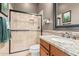 Well-appointed bathroom with tiled walk-in shower, granite vanity, and decorative mirror at 7589 W Firebird Dr, Glendale, AZ 85308