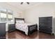Charming bedroom with wood floors, large window, and dark furnishings at 7589 W Firebird Dr, Glendale, AZ 85308
