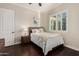 Cozy bedroom with wood floors, white walls, and bright natural light with decor at 7589 W Firebird Dr, Glendale, AZ 85308