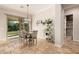 Charming dining area with a modern chandelier, sliding glass door to the backyard, and stylish travertine flooring at 7589 W Firebird Dr, Glendale, AZ 85308