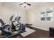 Bright exercise room features modern workout equipment, ceiling fan, and window shutters at 7589 W Firebird Dr, Glendale, AZ 85308