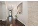 Inviting foyer with hardwood floors, elegant lighting, decorative niche, and wrought iron door creating a warm ambiance at 7589 W Firebird Dr, Glendale, AZ 85308