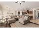 Spacious living room featuring a large sectional sofa, ceiling fan, and seamlessly connected to an open-concept kitchen at 7589 W Firebird Dr, Glendale, AZ 85308