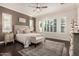 Comfortable main bedroom with dark wood floors, neutral walls, and a ceiling fan with decorative rug at 7589 W Firebird Dr, Glendale, AZ 85308