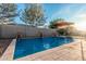 Backyard pool features stone water feature wall with an umbrella for shade during hot days at 7589 W Firebird Dr, Glendale, AZ 85308