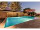 Backyard pool features stone water feature wall with an umbrella for shade during hot days at 7589 W Firebird Dr, Glendale, AZ 85308
