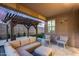 Cozy covered patio with outdoor furniture, pergola, and lush landscaping at 7844 W Molly Dr, Peoria, AZ 85383