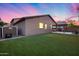 Home's exterior shows a verdant backyard with an extended covered patio featuring a built-in grill at 7844 W Molly Dr, Peoria, AZ 85383