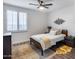 Bedroom featuring a comfortable bed, wood floors, a modern ceiling fan, and a set of windows with shutters at 7844 W Molly Dr, Peoria, AZ 85383