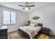 Bedroom featuring a comfortable bed, wood floors, a modern ceiling fan, and a set of windows with shutters at 7844 W Molly Dr, Peoria, AZ 85383
