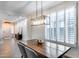 Bright dining room with a large wood table, shuttered windows, and contemporary lighting fixture at 7844 W Molly Dr, Peoria, AZ 85383