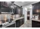 Modern kitchen featuring stainless steel appliances, granite counters, dark cabinetry, and ample countertop space at 7844 W Molly Dr, Peoria, AZ 85383