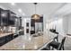Modern kitchen features a large island, stainless steel appliances, and dark cabinetry with granite countertops at 7844 W Molly Dr, Peoria, AZ 85383
