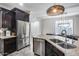 Spacious kitchen island with bar seating and dual sinks, complemented by stainless steel appliances and dark cabinetry at 7844 W Molly Dr, Peoria, AZ 85383