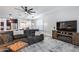 Relaxing living room featuring tile floors, a modern ceiling fan, and a fireplace with a wooden mantle at 7844 W Molly Dr, Peoria, AZ 85383