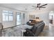 Bright living room featuring white walls, tile flooring, modern ceiling fan, and sliding glass doors to outdoor patio at 7844 W Molly Dr, Peoria, AZ 85383