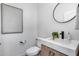 Modern powder room featuring marble countertop, vessel sink, round mirror, and stylish fixtures at 7844 W Molly Dr, Peoria, AZ 85383