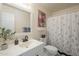 Bright bathroom with a white vanity, decorative mirror, and charming floral shower curtain at 8613 E Citrus Way, Scottsdale, AZ 85250