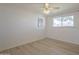 Cozy bedroom features a ceiling fan, large window with backyard view, and light, wood-look flooring at 8613 E Citrus Way, Scottsdale, AZ 85250