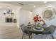 Cozy dining area with a circular table, place settings, fireplace views and decorative mirror at 8613 E Citrus Way, Scottsdale, AZ 85250