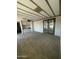 Spacious living room with neutral carpet, ceiling fan, and door leading to patio at 9068 E Chambers St, Mesa, AZ 85208