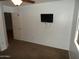 A neutral bedroom with a ceiling fan and a television mounted on the wall for entertainment at 10302 E Cicero Cir, Mesa, AZ 85207