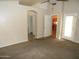 The carpeted living room features an arched doorway and access to an outdoor patio area at 10302 E Cicero Cir, Mesa, AZ 85207